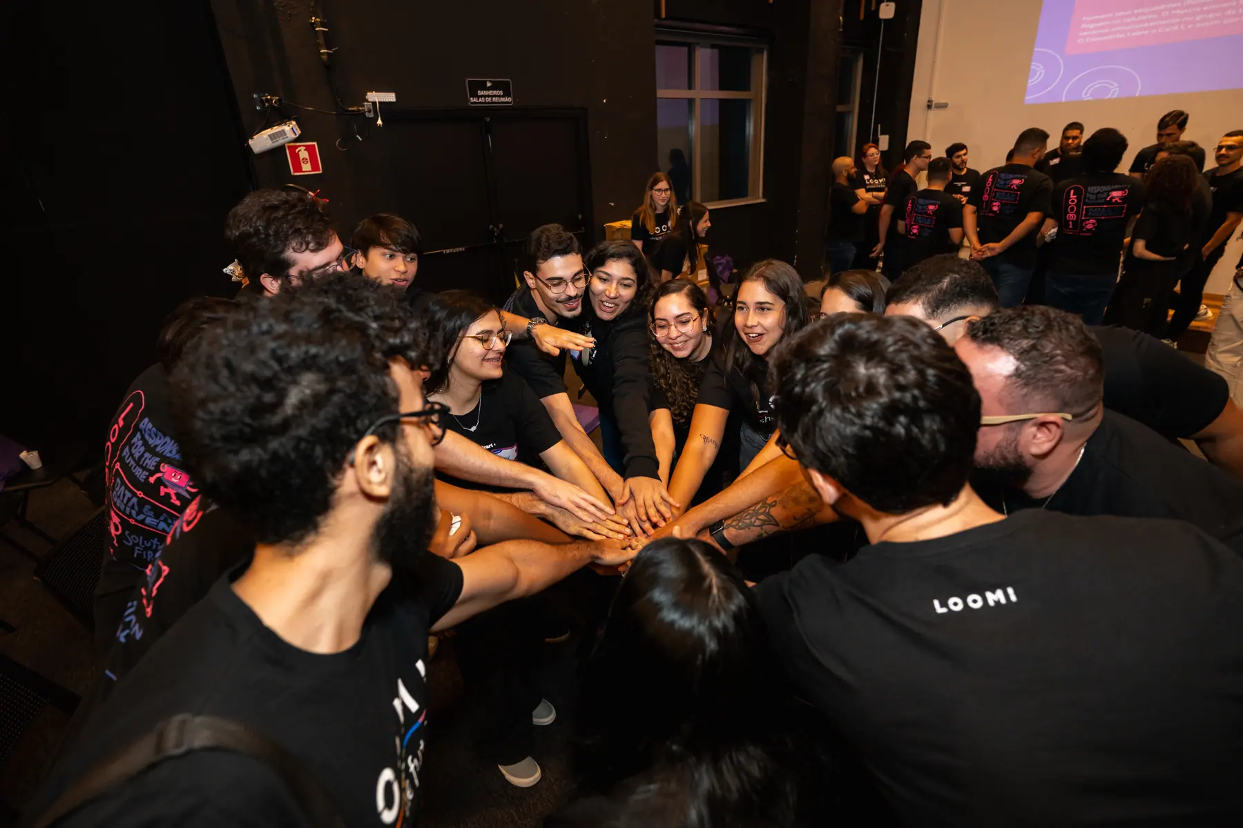 Time da Loomi em roda, com as mãos unidas no centro